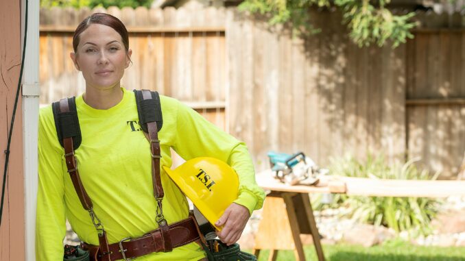 A woman in carpentry gear at work