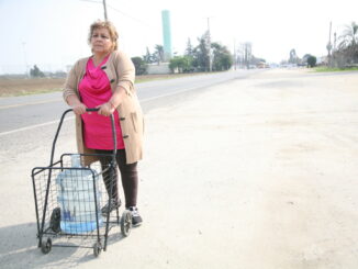 Sandra Garcia pushes a cart with bottled water