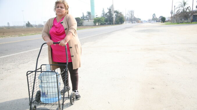 Sandra Garcia pushes a cart with bottled water