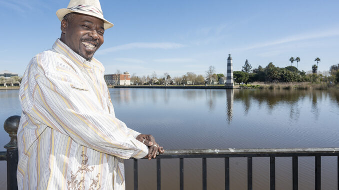 A man stands beside a lake