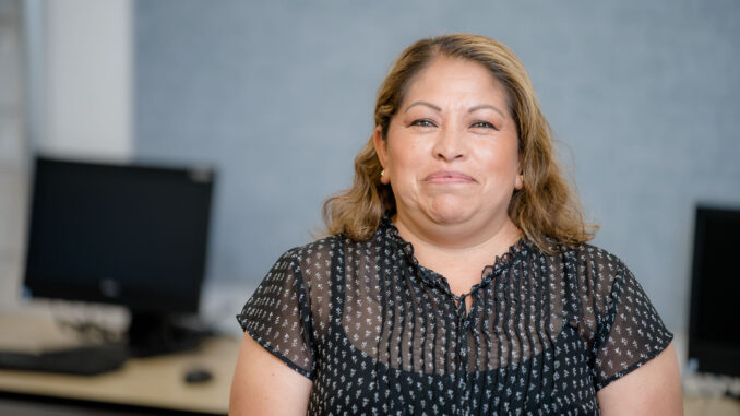 A woman in a black dress in a computer lab.