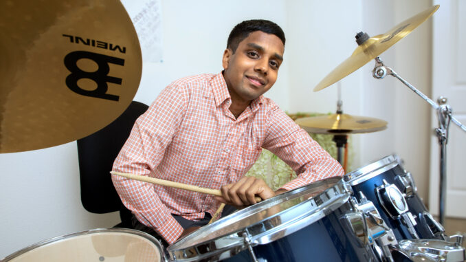 Portrait of Rahul Chintalapudi at home with his drums.