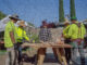 Jose Nunez doing construction work in a yard with four other men in hi-vis gear