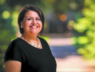 Ruth Rodríguez standing outside, smiling for the camera