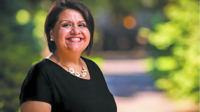 Ruth Rodríguez standing outside, smiling for the camera