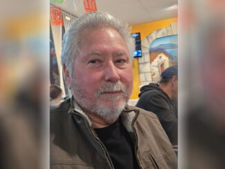 A selfie of Josue Salazar, an older man with gray hair and a gray beard in a brown jacket