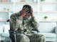 Upset black man sitting in wheelchair, wearing military uniform