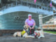 Portrait of Navy veteran Jude Litzenberger with her dogs Gunner, at left, and Archer near the USS Midway Museum at San Diego Bay.