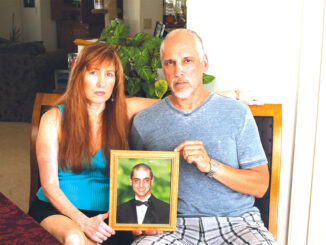 Ric y Jeannette Torchon sostienen un retrato de su hijo Alec Jacob Torchon, quien murió después de una sobredosis de analgésicos recetados.