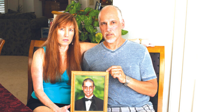 Ric y Jeannette Torchon sostienen un retrato de su hijo Alec Jacob Torchon, quien murió después de una sobredosis de analgésicos recetados.