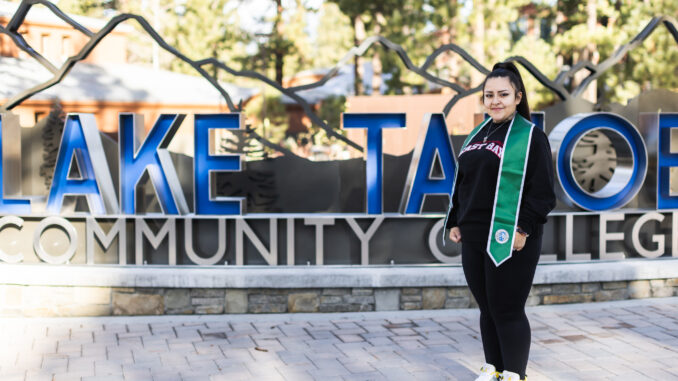 Lina Caro Flores standing in front of the Lake Tahoe Community College sign