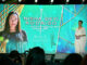 Nisha Devi Rodrigo's photo on a large screen during a presentation.