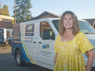 Joy Cohan, standing in front of a delivery van for Meals on Wheels Yolo County.