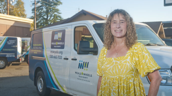 Joy Cohan, standing in front of a delivery van for Meals on Wheels Yolo County.