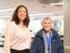 Two women, one older standing next to each other and smiling.